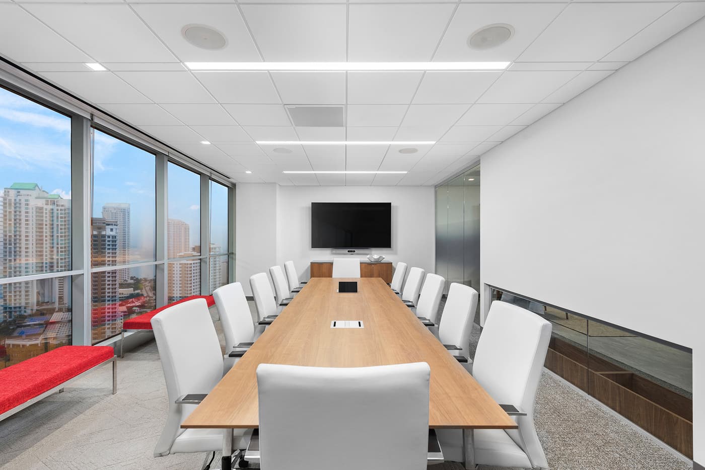Sompo International's Miami office: reception lounge beneath a folded walnut ceiling with the Sompo wall sign, photograph 3