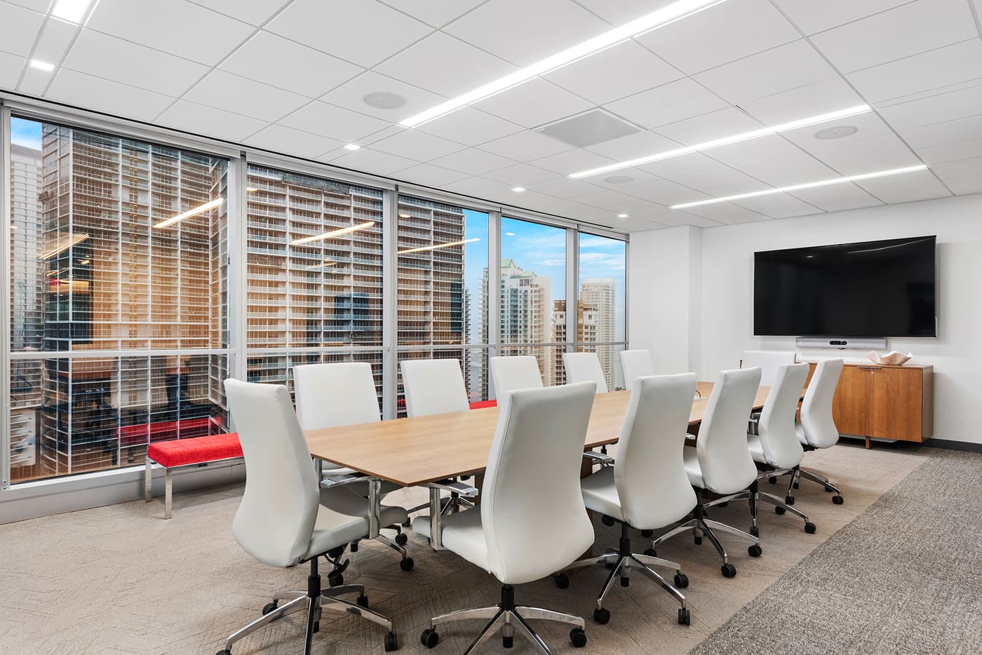 Sompo International's Miami office: reception lounge beneath a folded walnut ceiling with the Sompo wall sign, photograph 8