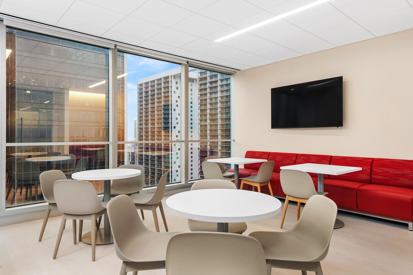 Sompo International's Miami office: reception lounge beneath a folded walnut ceiling with the Sompo wall sign, photograph 6
